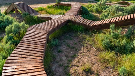 Panorama Elevated wooden bicycle tracks on a cycling park viewed on a sunny day. Homes and distant hills can be seen in the scenic background.の写真素材