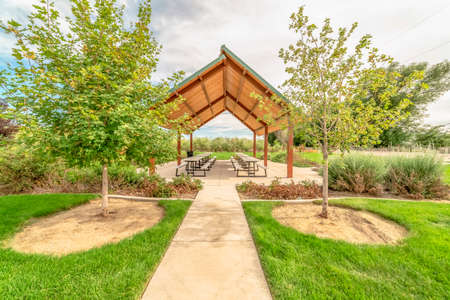 Beautiful view of a picnic pavilion at a park with pathway and trees in frontの写真素材