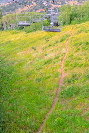 Chairlifts over mountain with grasses and trails in Park City Utah in summer