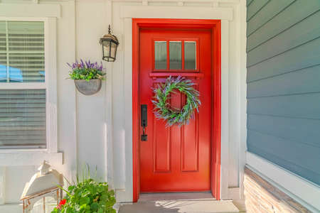 Red front door of modern home with green wreathの写真素材