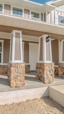 Vertical frame Front porch and door of new traditional home. The front porch and door of a new two storey, traditional home on a sunny, clear day.の写真素材