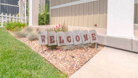 Panorama Welcome sign in front garden of traditional home. A welcome sign in the front garden of a traditional suburban home.の写真素材