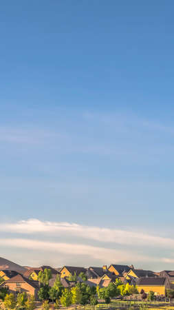 Vertical frame Sunny day view of homes in a neighborhood with mountain and blue sky backgroundの写真素材