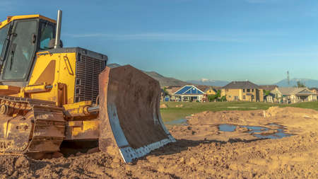 Panorama Bulldozer at a construction site with copy space. The vehicle has yellow paint, metal...