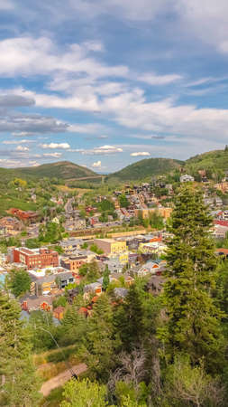 Vertical Ski Resort in Park City Utah with lush greenery and buildings viewed in summer. MOuntain landscape with cloudy blue sky overhead during off season.の写真素材