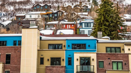 Panorama Residential buildings and houses on a snowy mountain in Park City Utah in winter. Coniferous trees and cloudy sky can also be seen in this landscape.の写真素材