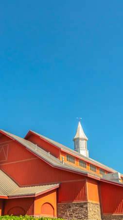 Vertical Colorful orange barn at a vinyard with clear blue sky background on a sunny dayの写真素材