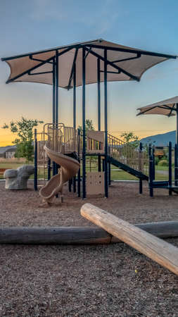 Vertical Neighborhood park with fun playground featuring slides and swings for childrenの写真素材