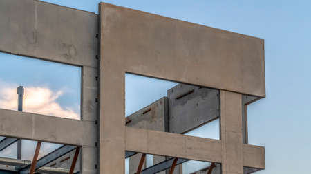 Panorama Exterior of modern building under construction against sky and clouds at sunset. A distant...