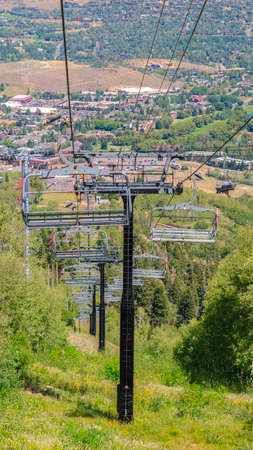 Vertical frame Chairlifts overlooking hiking trails and building on a summer day in Park City....