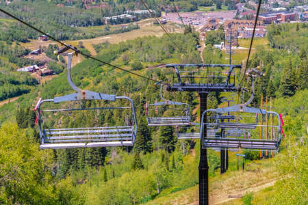 Chairlifts with scenic aerial view of buildings and hiking trails at off seasonの写真素材
