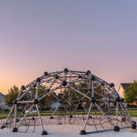 Square frame Metal climbing frame in a playground at sunset
