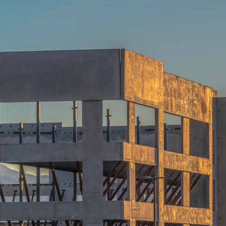Square frame Construction of a modern building with mountain and sky background at sunset