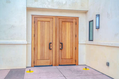 Closed double wooden entrance doors on cloudy day