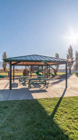 Vertical Covered picnic tables and benches near sunriseの写真素材