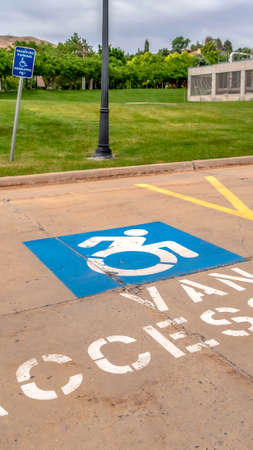 Vertical frame Handicapped parking lot with painted handicap symbol and Van Accessible sign. Close...