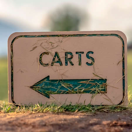 Square Views at a golf course with close up on a white Carts sign with green arrow. Grasses,...