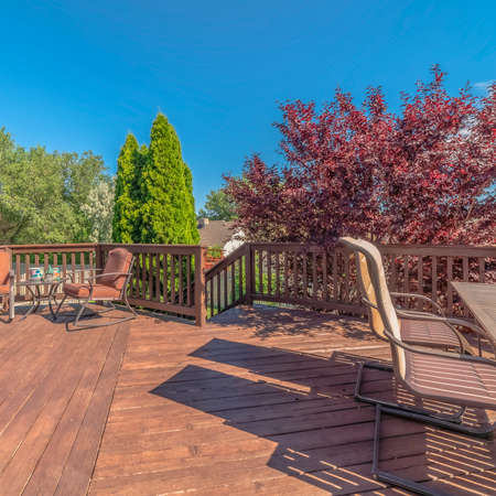 Square frame Balcony with furniture and stairs overlooking trees and blue sky on a sunny day