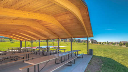 Pano Park pavilion with white tables and seats under the brown wooden ceilingの写真素材