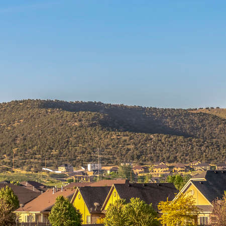 Square Scenic view of houses on a sunny day with mountain and blue sky backgroundの写真素材