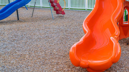 Pano frame Close up of bright and shiny orange slide at a park with childrens playground