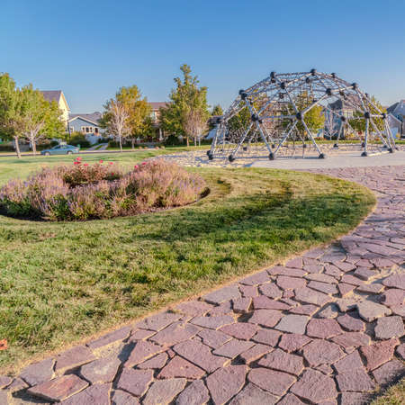 Square frame Curved path with crazy paving in an urban park leading towards a dome shaped climbing...