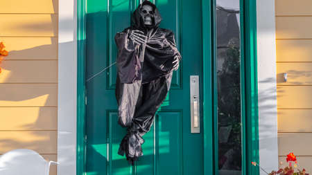Panorama A grim reaper decoration on a green front doorの写真素材