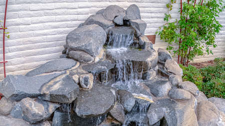 Panorama frame Stone cascade waterfall outdoor landscape design decoration with small round pool, viewed from high angleの写真素材
