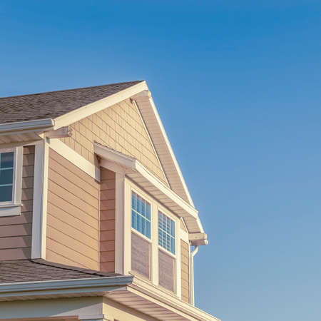 Square Upper floor of a small modern wooden clad suburban home with pitch roof and windows