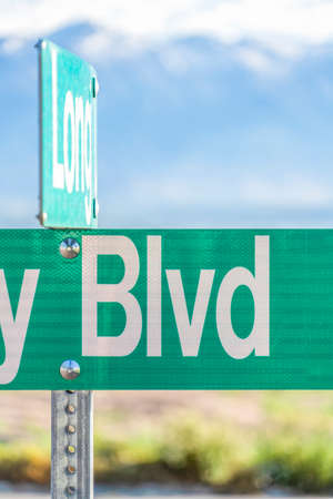 Selective focus on a green and white road street sign that reads Blvd. Abbreviation of boulevard on a sign with blurry nature background on a sunny day.の写真素材