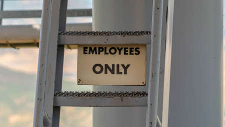 Panorama Park City Utah in summer with Employees Only sign and ladder under chairlifts. Views under ski lifts with blurry mountain landscape in the background at off season.の写真素材