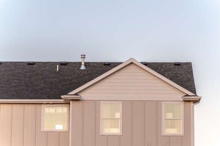 Simple American house with gable roof from low angle against clear blue skyの写真素材