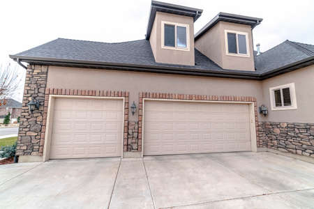 Urban house with a single and double garages with concrete driveway in close up viewの写真素材