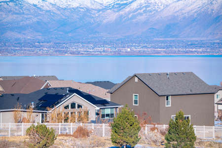 View over rooftops or houses in an estate of the Utah Lake and snow-capped mountains in winter