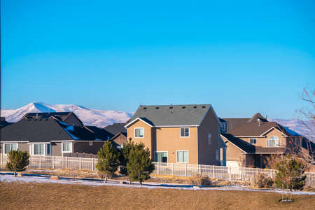 Traditional American houses in winter landscape with mountains across Utah valley region viewed in...