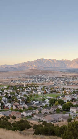 Vertical Overview of the Utah Valley, USA at sunrise with a view across residential houses to...