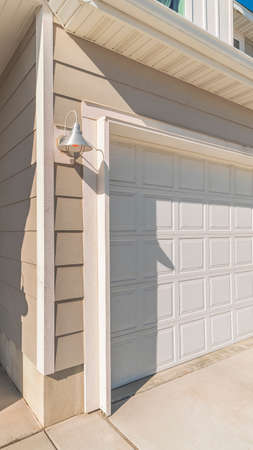 Vertical frame White garage door with recessed covered entrance door alongside in a modern urban houseの写真素材