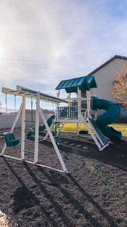 Vertical Swings and slides at a kids playground in a small walled park on a housing estate