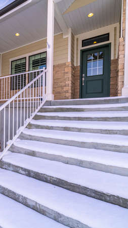 Vertical Fresh white snow covering a flight of exterior steps with railings leading to an entrance...