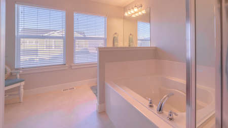 Panorama frame Fresh clean white modern bathroom interior with fitted bath and shower and blinds on...