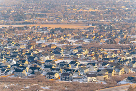 Tranquil neighborhood nestled amid hilly terrain covered with snow in winter. The homes have an extraordinary view of natural frosty scenery.の写真素材
