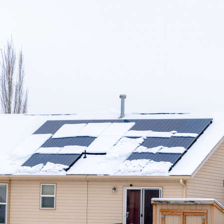 Photo Square frame Snow covered roof of home with solar panels against cloudy sky in winter. Bay...
