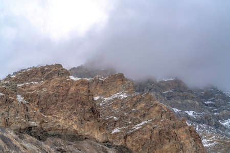 Rocky mountain scenery with overcast sky overhead in Provo Canyon Utah in winter. The rugged slopes are covered with some snow on this cold season.の写真素材
