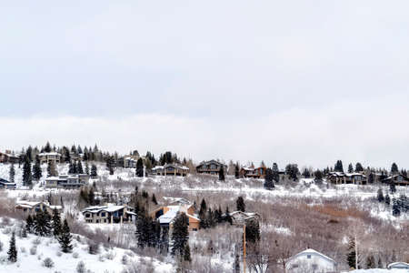Neighborhood homes sitting on snow covered mountain slope in Park City Utah. The residential...
