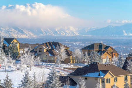 Homes on magnificent Wasatch Mountain setting with panoramic view of the valley. The scenic landscape is covered with snow on a sunny winter day.の写真素材