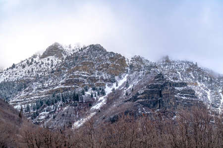 Natural landscape of Provo Canyon with steep slopes with frozen water in winter. Cloudy sky is over...