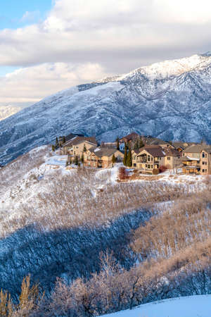 Homes nestled amid pristine Wasatch Mountain views blanketed with snow in winter. The houses are...