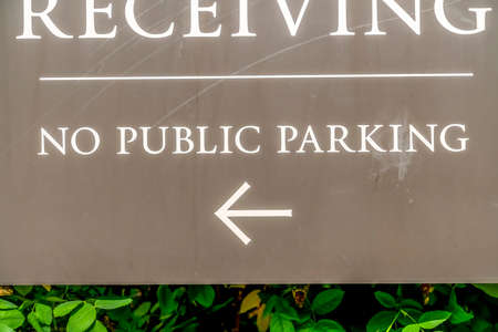 No Public parking sign with arrow at the Receiving area outside a building
