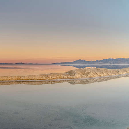Square frame Panorama view of pans at the Bonnievale Salt Flats, Utah at sunrise or sunset with a golden glow on the horizon in a wide scenic landscapeの写真素材