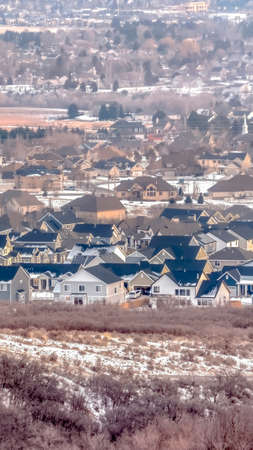 Vertical Houses in Alpine Utah neighborhood amid snowy hill and abundant trees in winter. A fusion of scenic residential and nature landscape in Utah Valley.の写真素材